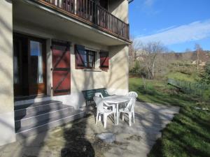 eine Terrasse mit Tisch und Stühlen vor einem Gebäude in der Unterkunft Lou camparol in Villeneuve
