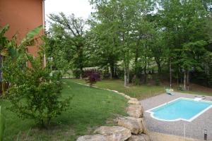 un patio con piscina y un patio con árboles en La Colline des Endrevies, en Saint-André-dʼAllas