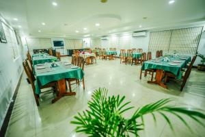 a restaurant with tables and chairs with green tablecloths at Hotel Golden Anchor ,Paradeep in Parādīp Garh