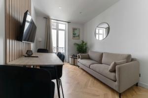 a living room with a couch and a table at Chez Virginie Triangle d'Or in Vichy
