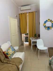 a living room with a couch and a table with chairs at residence Gaja in Gaeta +4 photos
