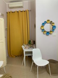 a table and chairs in a room with a yellow curtain at residence Gaja in Gaeta