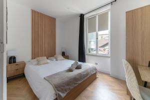 a bedroom with a large bed and a window at Chez Virginie Triangle d'Or in Vichy