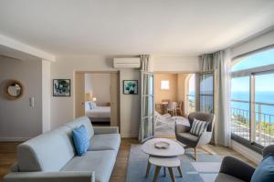 a living room with a couch and a table at Hôtel La Villa Douce in Rayol-Canadel-sur-Mer