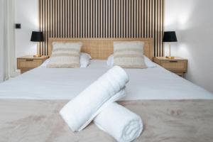 a large bed with white sheets and pillows at Chez Juliette Triangle d'Or - Rez de Chaussée in Vichy