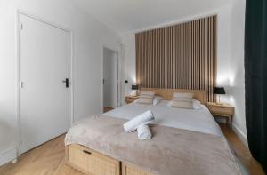 a bedroom with a large bed with two pillows at Chez Juliette Triangle d'Or - Rez de Chaussée in Vichy