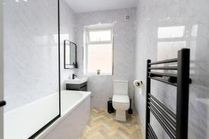 a bathroom with a tub and a toilet and a sink at Luxury 1-bed Near MCR Hospital & City Centre in Manchester +16 photos
