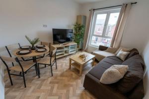 a living room with a couch and a table at Luxury 1-bed Near MCR Hospital & City Centre in Manchester