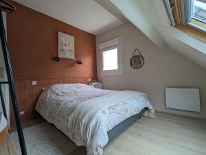 a bedroom with a large bed in a attic at Maison 86 Les Océanes in Damgan