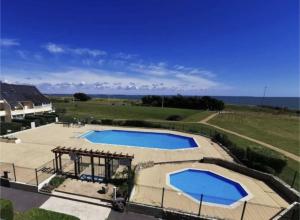 two swimming pools on a patio with the ocean in the background at Maison 86 Les Océanes in Damgan