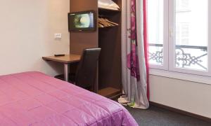 Cette chambre comprend un lit, un bureau et une fenêtre. dans l'établissement Hôtel Montsouris Orléans, à Paris