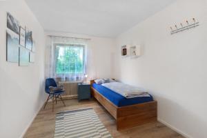 a bedroom with a bed and a chair and a window at Haus Petra in Kandern