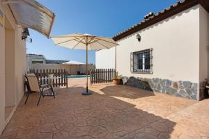 eine Terrasse mit einem Stuhl und einem Sonnenschirm in der Unterkunft La Solana in Chiclana de la Frontera