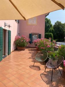 a patio with two chairs and some flowers at La Casa Di Mimi in Bardolino