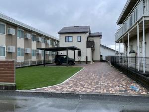 a car parked under a canopy in front of a building at 河口湖駅徒歩10分 ベルショッピングセンター徒歩6分 大型4ldk屋根裏付き 全室空調 in Wada
