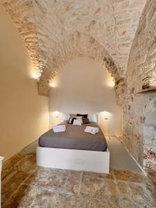 a bedroom with a bed in a stone wall at White Ostuni in Ostuni