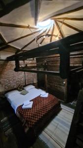 a bedroom with a bed in a room with a roof at La Colibe, cătun arhaic ecologic in Constanţa