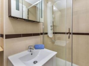 a bathroom with a sink and a glass shower at Jardines del mar III-2ª linea de playa Piscina y Parking Ideal familias Marina d'Or in El Borseral +14 photos