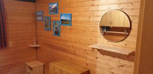a bathroom with a mirror and a wooden wall at Ferienhaus Bernau13, Rechbergblick in Bernau im Schwarzwald