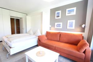 un salon avec un canapé et un lit dans l'établissement Rasmus 29, à Langeoog