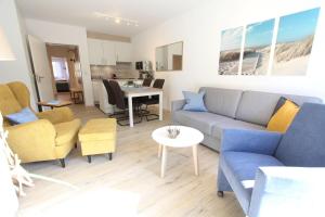 a living room with a couch and chairs and a table at Strandliebe in Langeoog