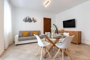 ポルト・トッレスにあるLuxury House Porto Torres Centerのリビングルーム(テーブル、白い椅子付)