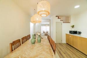 ein Esszimmer mit einem Tisch mit grünen Vasen darauf in der Unterkunft Casa de Julho - Beach House in Livramento