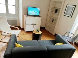 a living room with a blue couch and a tv at Centralis, 3 Chambres - Parking inclus in Cholet