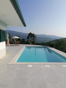 a swimming pool with a view of the mountains at Central Suites Arouca in Arouca