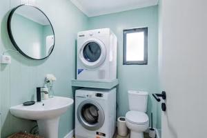 ein Badezimmer mit Waschmaschine und Waschbecken in der Unterkunft Casa de Julho - Beach House in Livramento + 28 Fotos