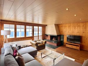 a living room with a couch and a fireplace at Chalet Gemsblick in Hospental