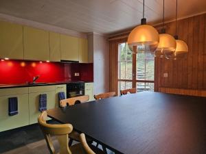 a kitchen with a black table and chairs in a room at Chalet Gemsblick in Hospental