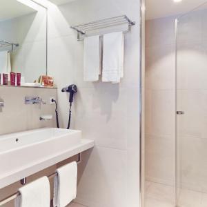 a bathroom with a sink and a shower at Mondorf Parc Hotel & Spa in Mondorf-les-Bains