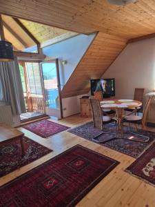 ein Wohnzimmer mit Tisch und Stühlen und Fenstern in der Unterkunft Singer-Hof in Krumpendorf am Wörthersee