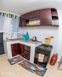 a kitchen with a stove and a sink at Hamptons Homes Stylish 1 Bedroom Stay close to Eldoret Town in Eldoret +10 photos