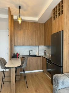 ティラナにあるTirana Center Boulevard Apartmentのキッチン(テーブル、黒い冷蔵庫付) +2枚の写真