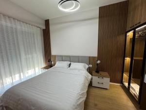 ティラナにあるTirana Center Boulevard Apartmentの大きな白いベッドと窓のある寝室