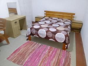 a bedroom with a bed and a table and a rug at PARADISEs in Nouakchott