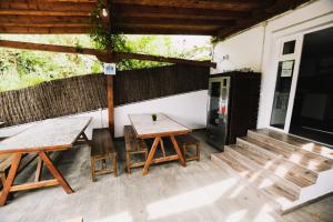 eine Terrasse mit zwei Bänken, einem Tisch und einem Kühlschrank in der Unterkunft SURFbase Loredo in Loredo