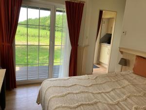 a bedroom with a bed and a large sliding glass door at Bos & Pingo in Kollum
