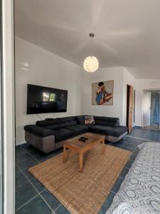 a living room with a black couch and a coffee table at Rosemary Resort in Cesarica