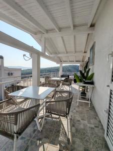 a patio with tables and chairs on a balcony at Rosemary Resort in Cesarica