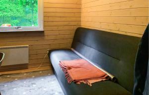 a black couch in a room with a window at Three Bedroom Cozy Home In Ebeltoft in Ebeltoft
