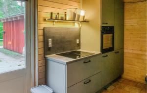 a kitchen with a stove top oven next to a window at Three Bedroom Cozy Home In Ebeltoft in Ebeltoft