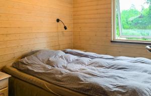 an unmade bed in a room with a window at Three Bedroom Cozy Home In Ebeltoft in Ebeltoft