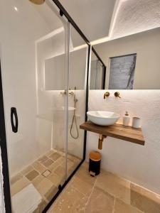 a bathroom with a glass shower and a sink at White Ostuni in Ostuni