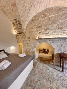 a bedroom with a bed in a stone wall at White Ostuni in Ostuni