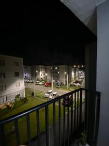 einen Balkon mit Blick auf einen Parkplatz in der Nacht in der Unterkunft Apartamento Completo Mobiliado in Caruaru