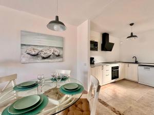 a kitchen and dining room with a glass table at Queen Amanay - terrazza, confortevole, tranquillo, Wi-Fi, AC in Costa Calma