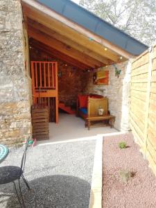 a patio in a stone building with a table and a chair at La Loge de Fleur in Anglars-Saint-Félix